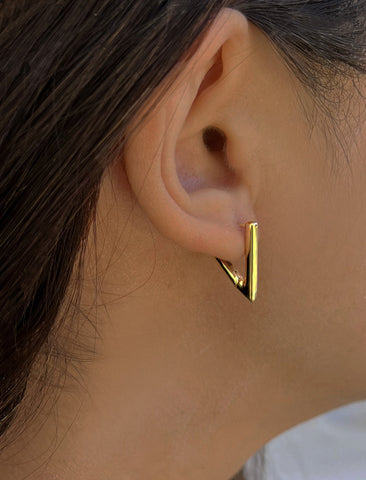 Image Title Female model wearing ACHIEVE TRIANGLE GEOMETRIC HUGGIE EARRINGS IN 18K GOLD VERMEIL With Sterling Silver base by Sonia Hou Jewelry