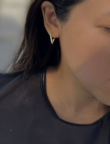 Image Title Female Model wearing ACHIEVE TRIANGLE GEOMETRIC HUGGIE EARRINGS in Sterling Silver by Sonia Hou Jewelry