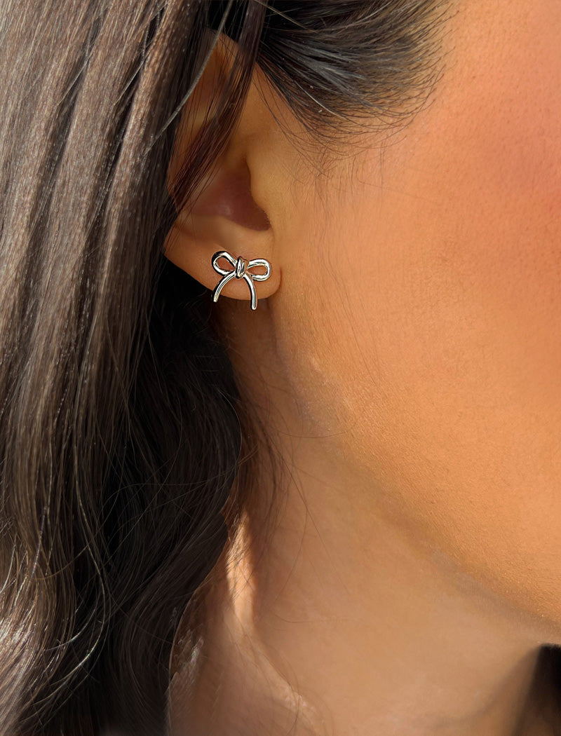 Image Title Female model wearing Holiday Coquette Bow Festive Christmas Stud Earrings in Sterling Silver by AAPI Celebrity Jewelry Designer Sonia Hou