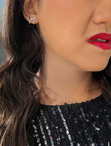 Image Title Female model wearing Holiday Coquette Bow Festive Christmas Stud Earrings in Sterling Silver by AAPI Celebrity Jewelry Designer Sonia Hou