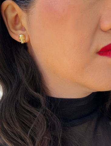 Image Title Woman wearing Culturally inclusive Day Of The Dead Mexican Sugar Skull Stud Earrings in 18K Gold over Sterling Silver by Sonia Hou, a celebrity AAPI Chinese demi-fine jewelry designer. This holiday is also known as Dia De Los Muertos, and can also be worn for Halloween!