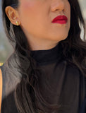 Image Title Woman wearing Culturally inclusive Day Of The Dead Mexican Sugar Skull Stud Earrings in 18K Gold over Sterling Silver by Sonia Hou, a celebrity AAPI Chinese demi-fine jewelry designer. This holiday is also known as Dia De Los Muertos, and can also be worn for Halloween!