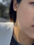 Female model wearing tiny dainty small minimalist inclusive Evil Eye Stud Earrings, inspired by Greek culture, in 18K Gold Vermeil With Sterling Silver base by Sonia Hou, a celebrity AAPI Chinese demi-fine fashion costume jewelry designer