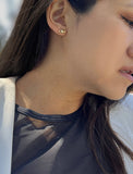 Image Title Female model wearing tiny dainty small minimalist inclusive Evil Eye Stud Earrings, inspired by Greek culture, in 18K Gold Vermeil With Sterling Silver base by Sonia Hou, a celebrity AAPI Chinese demi-fine fashion costume jewelry designer