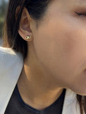 Female model wearing tiny dainty small minimalist inclusive Evil Eye Stud Earrings, inspired by Greek culture, in 18K Gold Vermeil With Sterling Silver base by Sonia Hou, a celebrity AAPI Chinese demi-fine fashion costume jewelry designer