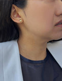 Female model wearing tiny dainty small minimalist inclusive Evil Eye Stud Earrings, inspired by Greek culture, in 18K Gold Vermeil With Sterling Silver base by Sonia Hou, a celebrity AAPI Chinese demi-fine fashion costume jewelry designer