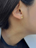 Female model wearing tiny dainty small minimalist inclusive Evil Eye Stud Earrings, inspired by Greek culture, in 18K Gold Vermeil With Sterling Silver base by Sonia Hou, a celebrity AAPI Chinese demi-fine fashion costume jewelry designer