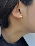 Image Title Female model wearing tiny dainty small minimalist inclusive Evil Eye Stud Earrings, inspired by Greek culture, in 18K Gold Vermeil With Sterling Silver base by Sonia Hou, a celebrity AAPI Chinese demi-fine fashion costume jewelry designer