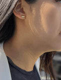 Image Title Female model wearing tiny dainty small minimalist inclusive Evil Eye Stud Earrings, inspired by Greek culture, in 18K Gold Vermeil With Sterling Silver base by Sonia Hou, a celebrity AAPI Chinese demi-fine fashion costume jewelry designer