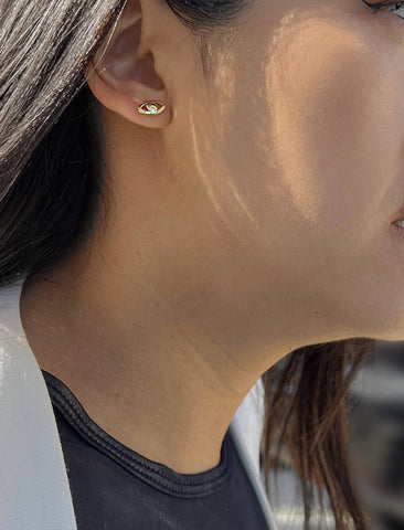 Image Title Female model wearing tiny dainty small minimalist inclusive Evil Eye Stud Earrings, inspired by Greek culture, in 18K Gold Vermeil With Sterling Silver base by Sonia Hou, a celebrity AAPI Chinese demi-fine fashion costume jewelry designer