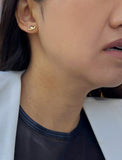 Female model wearing tiny dainty small minimalist inclusive Evil Eye Stud Earrings, inspired by Greek culture, in 18K Gold Vermeil With Sterling Silver base by Sonia Hou, a celebrity AAPI Chinese demi-fine fashion costume jewelry designer