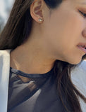 Image Title Female model wearing tiny dainty small minimalist inclusive Evil Eye Stud Earrings, inspired by Greek culture, in 925 Sterling Silver by Sonia Hou, a celebrity Asian AAPI Chinese demi-fine fashion costume jewelry designer