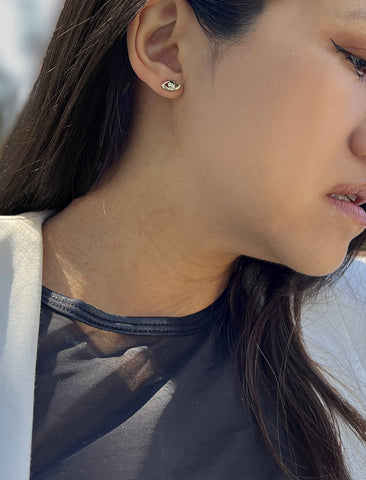 Image Title Female model wearing tiny dainty small minimalist inclusive Evil Eye Stud Earrings, inspired by Greek culture, in 925 Sterling Silver by Sonia Hou, a celebrity Asian AAPI Chinese demi-fine fashion costume jewelry designer