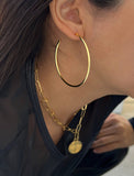 Female model wearing big medium large thin round circle PERFECT 50mm 2 inch hoop stacking lightweight everyday statement earrings in 18K Gold Vermeil With 925 Sterling Silver base by Sonia Hou, a celebrity AAPI Chinese demi-fine jewelry designer