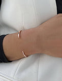 Female model wearing adjustable minimalist simple Success Thin Cuff Chunky Bold Layering Stacking Statement 2 Way convertible Bangle Cuff Open Bracelet in 18K rose gold vermeil with 925 sterling silver base by Sonia Hou, a celebrity AAPI Chinese demi-fine fashion costume jewelry designer