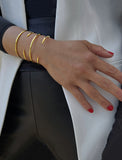 Female model wearing adjustable minimalist simple Success Thin Cuff Chunky Bold Layering Stacking Statement 2 Way convertible Bangle Cuff Open Bracelet in 18K Gold Vermeil with 925 sterling silver base by Sonia Hou, a celebrity AAPI Chinese demi-fine fashion costume jewelry designer