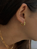 Image Title Female model wearing minimalist mini tiny small chunky bold thick dainty stacking layering statement round INNOVATE Hexagon Huggie Hoop Earrings in 18K Gold Vermeil With 925 Sterling Silver base by Sonia Hou, a celebrity AAPI Chinese demi-fine jewelry designer