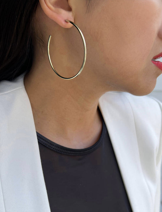 Female model wearing big medium large thin round circle PERFECT 50mm or 2 inch hoop stacking lightweight everyday statement earrings in 925 Sterling Silver by Sonia Hou, a celebrity AAPI Chinese demi-fine jewelry designer