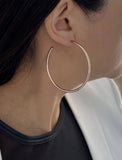 Female model wearing big medium large thin round circle PERFECT 50mm or 2 inch hoop stacking lightweight everyday statement earrings in 18K Rose Gold Vermeil With 925 Sterling Silver base by Sonia Hou, a celebrity AAPI Chinese demi-fine jewelry designer