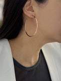 Female model wearing big medium large thin round circle PERFECT 50mm or 2 inch hoop stacking lightweight everyday statement earrings in 18K Rose Gold Vermeil With 925 Sterling Silver base by Sonia Hou, a celebrity AAPI Chinese demi-fine jewelry designer