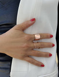 Female model wearing wide RICH thick bold chunky statement cigar band ring in 18k rose gold vermeil with 925 sterling silver base by Sonia Hou, a celebrity AAPI Chinese demi-fine jewelry designer