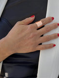 Female model wearing wide RICH thick bold chunky statement cigar band ring in 18K rose gold vermeil with a 925 sterling silver base by Sonia Hou, a celebrity AAPI Chinese demi-fine jewelry designer