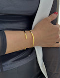 Female model wearing adjustable minimalist simple Success Thin Cuff Chunky Bold Layering Stacking Statement 2 Way convertible Bangle Cuff Open Bracelet in 18K Gold Vermeil with 925 sterling silver base by Sonia Hou, a celebrity AAPI Chinese demi-fine fashion costume jewelry designer