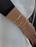 Female model wearing adjustable minimalist simple Success Thin Cuff Chunky Bold Layering Stacking Statement 2 Way convertible Bangle Cuff Open Bracelet in 18K Gold Vermeil with 925 sterling silver base by Sonia Hou, a celebrity AAPI Chinese demi-fine fashion costume jewelry designer