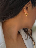 A close-up side profile of a woman wearing a small gold V-shaped hoop earring. ACHIEVE TRIANGLE GEOMETRIC HUGGIE EARRINGS IN 18K GOLD Over Sterling Silver by Sonia Hou Jewelry