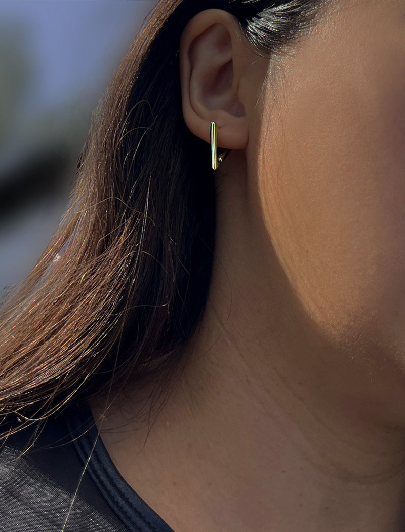 Female model wearing ACHIEVE TRIANGLE GEOMETRIC HUGGIE EARRINGS in Sterling Silver by Sonia Hou Jewelry