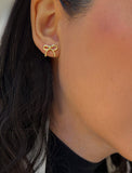 Female model wearing Holiday Coquette Bow Festive Christmas Stud Earrings in 18K Gold Over With Sterling Silver by AAPI Celebrity Jewelry Designer Sonia Hou 