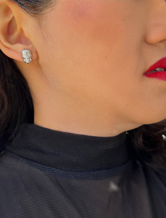 Woman wearing Culturally inclusive Day Of The Dead Mexican Sugar Skull Stud Earrings in Sterling Silver by Sonia Hou, a celebrity AAPI Chinese demi-fine jewelry designer. This holiday is also known as Dia De Los Muertos, and can also be worn for Halloween!