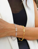 18K Gold vermeil and sterling silver bracelet on a person's wrist with a white blazer and black top. Our medium Essential paperclip link chain bracelet is perfect for everyday wear. Designed by AAPI celebrity jewelry designer SONIA HOU.