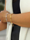 18K Gold vermeil and sterling silver bracelet on a person's wrist with a white blazer and black top. Our medium Essential paperclip link chain bracelet is perfect for everyday wear. Designed by AAPI celebrity jewelry designer SONIA HOU.