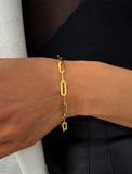 18K gold vermeil (sterling silver base) chain bracelet on a person's wrist against a black background.  Our medium Essential paperclip link chain bracelet is perfect for everyday wear. Designed by AAPI celebrity jewelry designer SONIA HOU.
