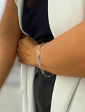 Sterling Silver chain bracelet on a person's wrist against a black background.  Our medium Essential paperclip link chain bracelet is perfect for everyday wear. Designed by AAPI celebrity jewelry designer SONIA HOU.