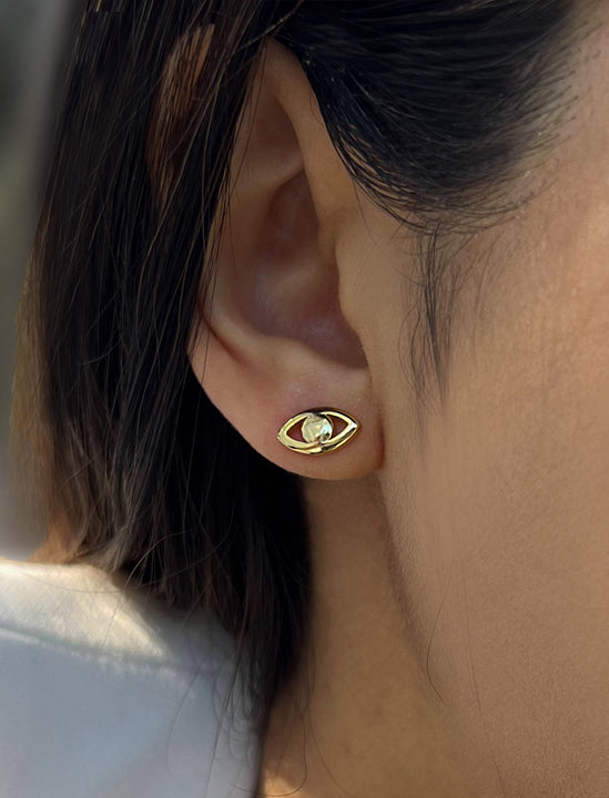 Female model wearing tiny dainty small minimalist inclusive Evil Eye Stud Earrings, inspired by Greek culture, in 18K Gold Vermeil With Sterling Silver base by Sonia Hou, a celebrity AAPI Chinese demi-fine fashion costume jewelry designer