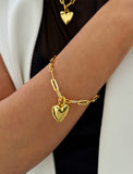 18K Gold Vermeil bracelet with a heart-shaped charm on a wrist against a white background. Fall in love with this timeless statement piece — a modern take on the classic heart motif. Featuring a bold yet feminine Puffy Heart charm suspended from a sleek link chain in 18k gold vermeil, this bracelet radiates effortless confidence and charm. Designed by AAPI celebrity jewelry designer SONIA HOU