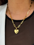 18K Gold vermeil chain necklace with a heart pendant worn by a person. Featuring a bold yet feminine Puffy Heart charm suspended from a sleek link chain, this bracelet radiates effortless confidence and charm. Designed to symbolize love, self-expression, and empowerment, the puffy heart serves as a daily reminder to lead with compassion and strength — Designed by AAPI celebrity jewelry designer SONIA HOU.
