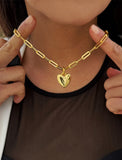 18K Gold vermeil chain necklace with a heart pendant worn by a person. Featuring a bold yet feminine Puffy Heart charm suspended from a sleek link chain, this bracelet radiates effortless confidence and charm. Designed to symbolize love, self-expression, and empowerment, the puffy heart serves as a daily reminder to lead with compassion and strength — Designed by AAPI celebrity jewelry designer SONIA HOU.

