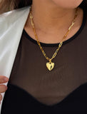 18K Gold vermeil chain necklace with a heart pendant worn by a person. Featuring a bold yet feminine Puffy Heart charm suspended from a sleek link chain, this bracelet radiates effortless confidence and charm. Designed to symbolize love, self-expression, and empowerment, the puffy heart serves as a daily reminder to lead with compassion and strength — Designed by AAPI celebrity jewelry designer SONIA HOU.
