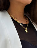 18K Gold vermeil chain necklace with a heart pendant worn by a person. Featuring a bold yet feminine Puffy Heart charm suspended from a sleek link chain, this bracelet radiates effortless confidence and charm. Designed to symbolize love, self-expression, and empowerment, the puffy heart serves as a daily reminder to lead with compassion and strength — Designed by AAPI celebrity jewelry designer SONIA HOU.
