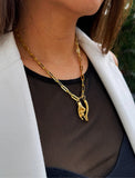 Person wearing a waterproof Italian Hand pendant necklace—also known as Mano Cornuta or the “Horned Hand” amulet and Italian Horn  in 18K Gold PVD stainless steel.  Designed for everyone who values inclusivity, diversity, and meaning, it’s a timeless statement of strength and modern style. It's perfect for everyday wear. Designed by AAPI celebrity jewelry designer SONIA HOU.