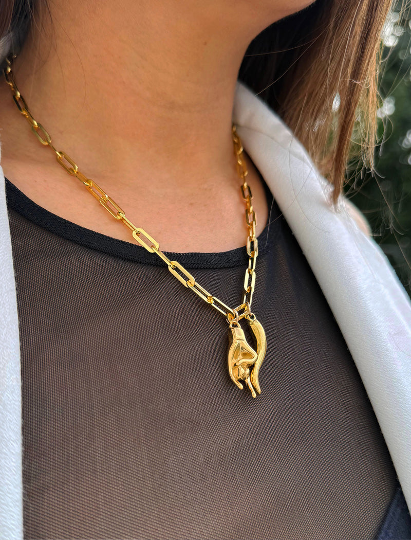 Person wearing an Italian Hand pendant—also known as Mano Cornuta or the “Horned Hand” amulet in 18K Gold Vermeil (sterling Silver base).  Designed for everyone who values inclusivity, diversity, and meaning, it’s a timeless statement of strength and modern style. It's perfect for everyday wear. Designed by AAPI celebrity jewelry designer SONIA HOU.