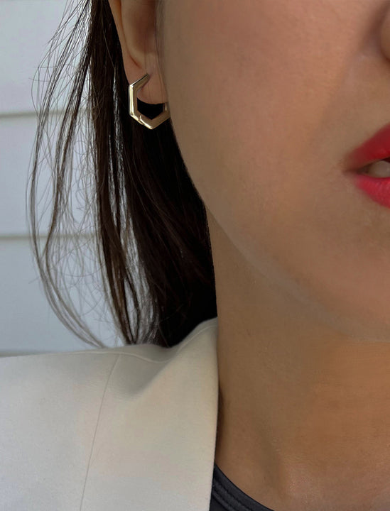 Female model wearing Minimalist mini tiny small chunky bold thick dainty stacking layering statement round INNOVATE Hexagon Huggie Hoop Earrings in 925 Sterling Silver by Sonia Hou, a celebrity Asian AAPI Chinese demi-fine jewelry designer