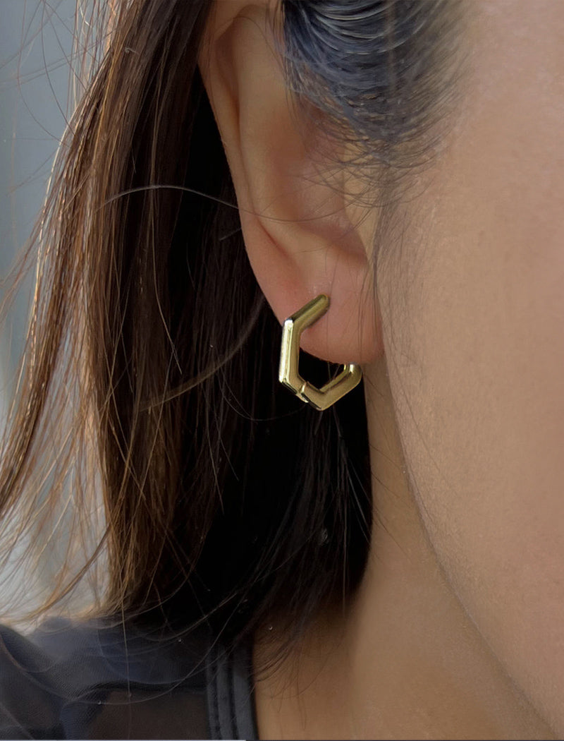 Female model wearing Minimalist mini tiny small chunky bold thick dainty stacking layering statement round INNOVATE Hexagon Huggie Hoop Earrings in 925 Sterling Silver by Sonia Hou, a celebrity Asian AAPI Chinese demi-fine jewelry designer