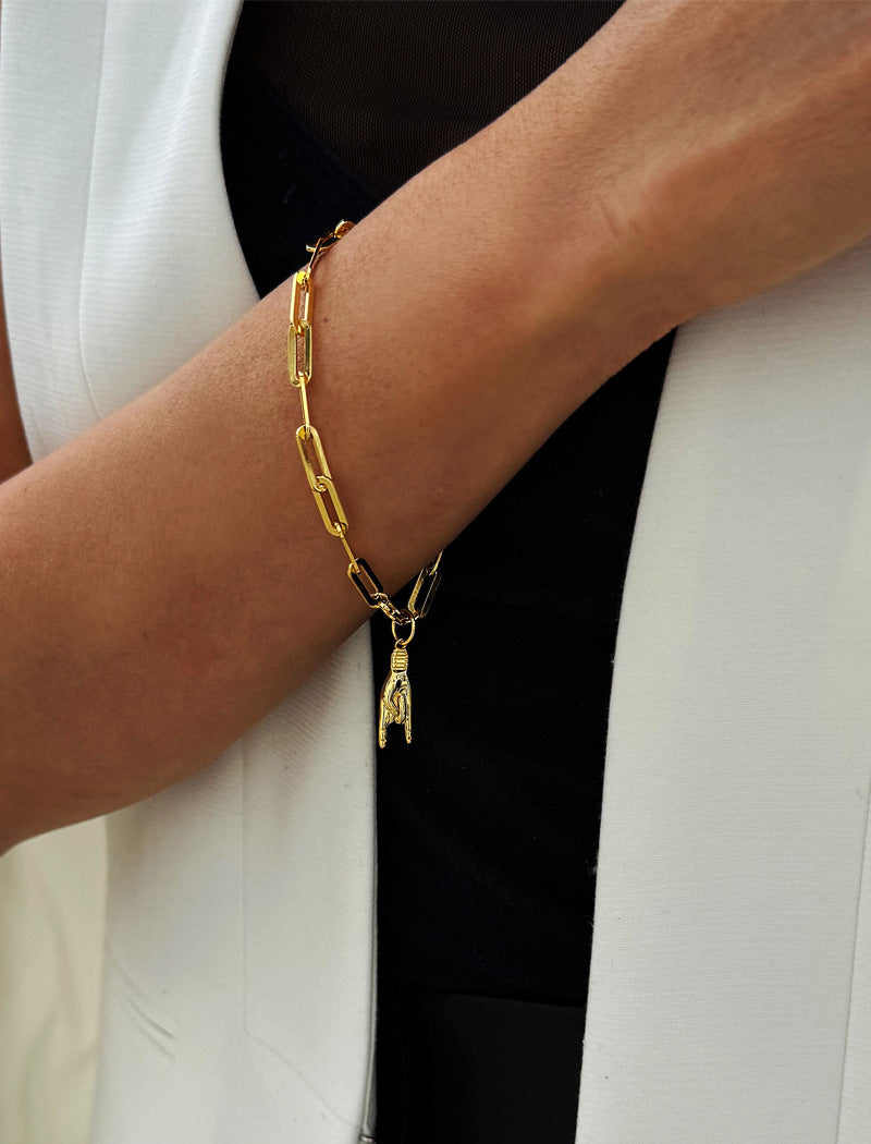 18K gold vermeil (sterling silver base) chain bracelet with a hand charm on a wrist. Rooted in ancient Italian tradition, the Italian Hand — also known as Mano Cornuta or the “Horned Hand” — has long been worn as a protective amulet to ward off the Evil Eye and negative energy. Symbolizes strength, defense, and good fortune. Designed by AAPI celebrity jewelry designer SONIA HOU.
