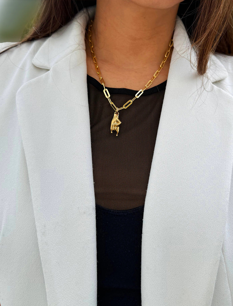 Person wearing an Italian Hand pendant—also known as Mano Cornuta or the “Horned Hand” amulet in 18K Gold Vermeil (sterling Silver base).  Designed for everyone who values inclusivity, diversity, and meaning, it’s a timeless statement of strength and modern style. It's perfect for everyday wear. Designed by AAPI celebrity jewelry designer SONIA HOU.