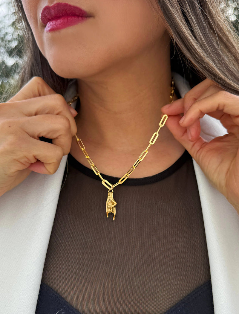 Person wearing a waterproof Italian Hand pendant necklace—also known as Mano Cornuta or the “Horned Hand” amulet in 18K Gold PVD stainless steel.  Designed for everyone who values inclusivity, diversity, and meaning, it’s a timeless statement of strength and modern style. It's perfect for everyday wear. Designed by AAPI celebrity jewelry designer SONIA HOU.