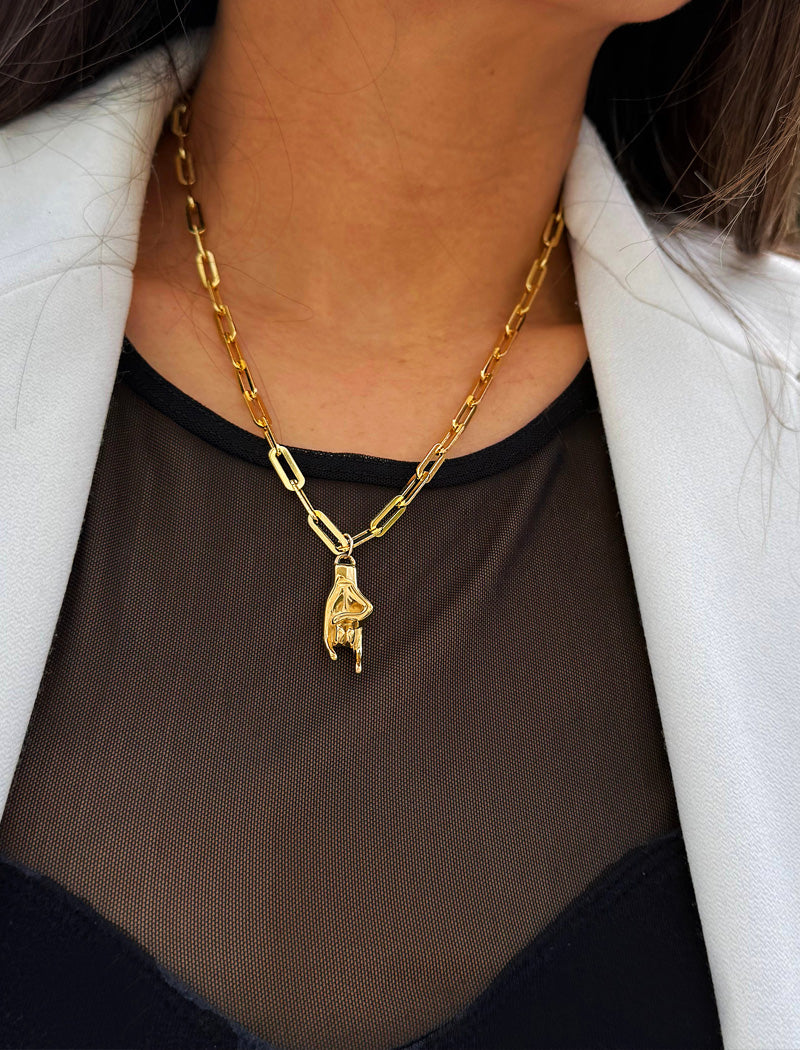 Person wearing an Italian Hand pendant—also known as Mano Cornuta or the “Horned Hand” amulet in 18K Gold Vermeil (sterling Silver base).  Designed for everyone who values inclusivity, diversity, and meaning, it’s a timeless statement of strength and modern style. It's perfect for everyday wear. Designed by AAPI celebrity jewelry designer SONIA HOU.